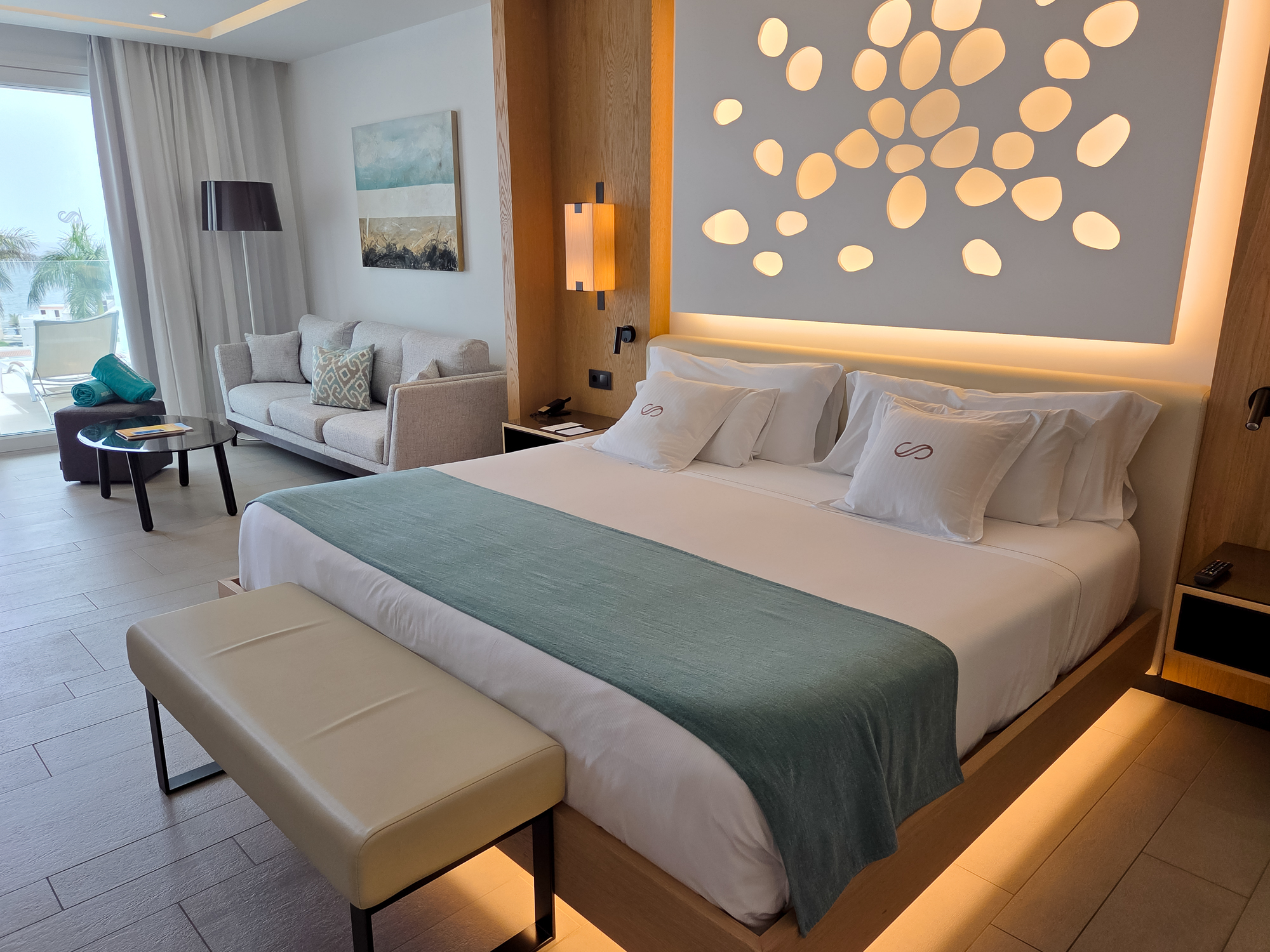 2220 Corales Beach Junior Suite-2 junior suite furniture in royal hideaway corales beach ocean view terrace coffee table, sofa, painting, double bed, decorative lights,